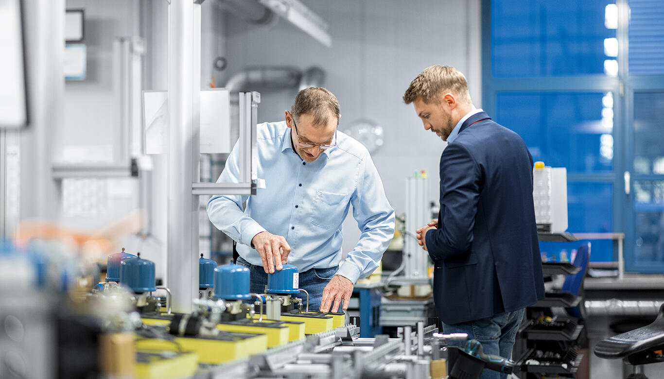 [Translate to Englisch:] Zwei Mitarbeiter begutachten Produktion